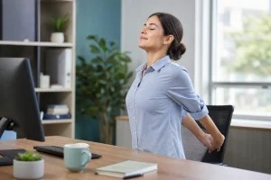 office worker on computer stretch at workplace to get relief from posture related tenssion